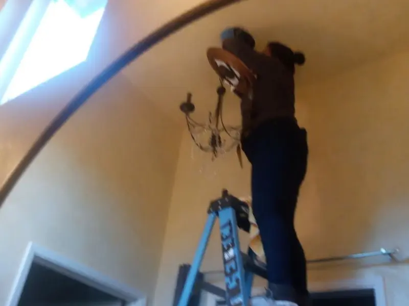 Electrician installing a chandelier in a Pilesgrove residence